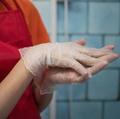 A woman demonstrating the use of Diamond Clear Vinyl Exam Gloves